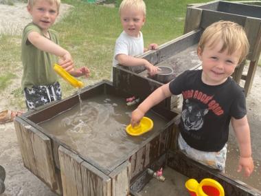 Børn leger bed vand på legepladsen